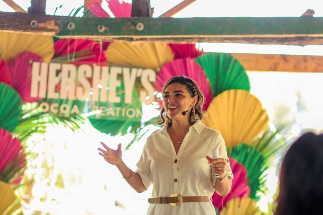 A unos días de celebrar el Día Nacional del Cacao y Chocolate (2 de septiembre), Hershey México anunció el lanzamiento de su nuevo chocolate: Hershey's Cocoa Creations, su primera barra elaborada con cacao 100% de origen mexicano. “Con el lanzamiento de la nueva barra Hershey’s Cocoa Creations, celebramos la tradición y las raíces culturales de México al deleite del cacao, al mismo tiempo que reafirmamos nuestro compromiso de mejorar la vida de los productores y sus comunidades a través del Proyecto Cacao Hershey, con el que estamos cumpliendo 11 años”, dijo Mariana Carranza, Directora de Marketing en Hershey México. “Estamos orgullosos de trabajar de la mano de los agricultores, promoviendo prácticas sostenibles y contribuyendo a su crecimiento y al de sus comunidades”, señaló. El cacao utilizado en la barra proviene principalmente de Tabasco y Chiapas. En este último estado es donde se realiza el Proyecto Cacao Hershey desde hace 11 años y que inició en 2007, luego de que una fuerte plaga de Moniliasis (enfermedad que afecta severamente al fruto del cacao) causara una pérdida de entre 90% y 95% de la producción de las parcelas e impactara negativamente a los productores de la región. Esto motivó a Hershey México, junto con socios como ECOM y Fundación Cacao México, a tomar cartas en el asunto y brindar todo su apoyo a la comunidad cacaotera de Chiapas, con el fin de preservar este fruto que representa las raíces de México. Como resultado de esta iniciativa, se han entregado más de 500,000 plantas de cacao resistentes a la monilia a 17 comunidades de Chiapas, se ha capacitado a más de 1,200 productores y se han renovado más de 500 hectáreas de cultivo. “El Proyecto Cacao Hershey refleja el compromiso global de Hershey para hacer que las comunidades productoras de cacao sean más fuertes para las generaciones venideras”, dijo Carranza. “Junto con nuestros socios, estamos proporcionando a los productores de cacao capacitación y apoyo para fortalecer sus habilidades, promover prácticas agrícolas sustentables y amigables con el medio ambiente y así contribuir al futuro confiable del cacao mexicano”. La nueva barra Hershey's Cocoa Creations tiene un alto contenido en cacao (70%), proporcionando una experiencia única de aromas y sabores para los paladares más exigentes. Además, su empaque celebra la cultura mexicana, resaltando el origen del cacao.